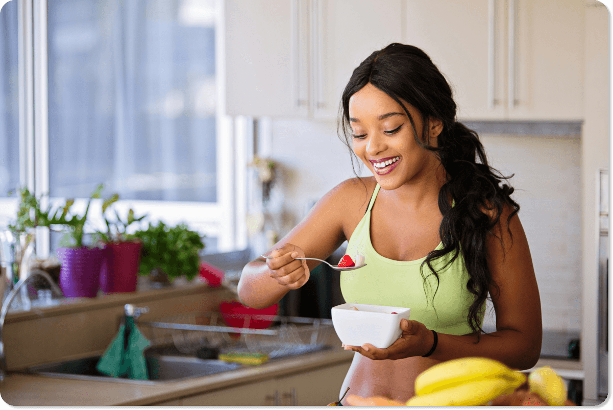 Background image of a woman in a kitchen holding a fruit bowl